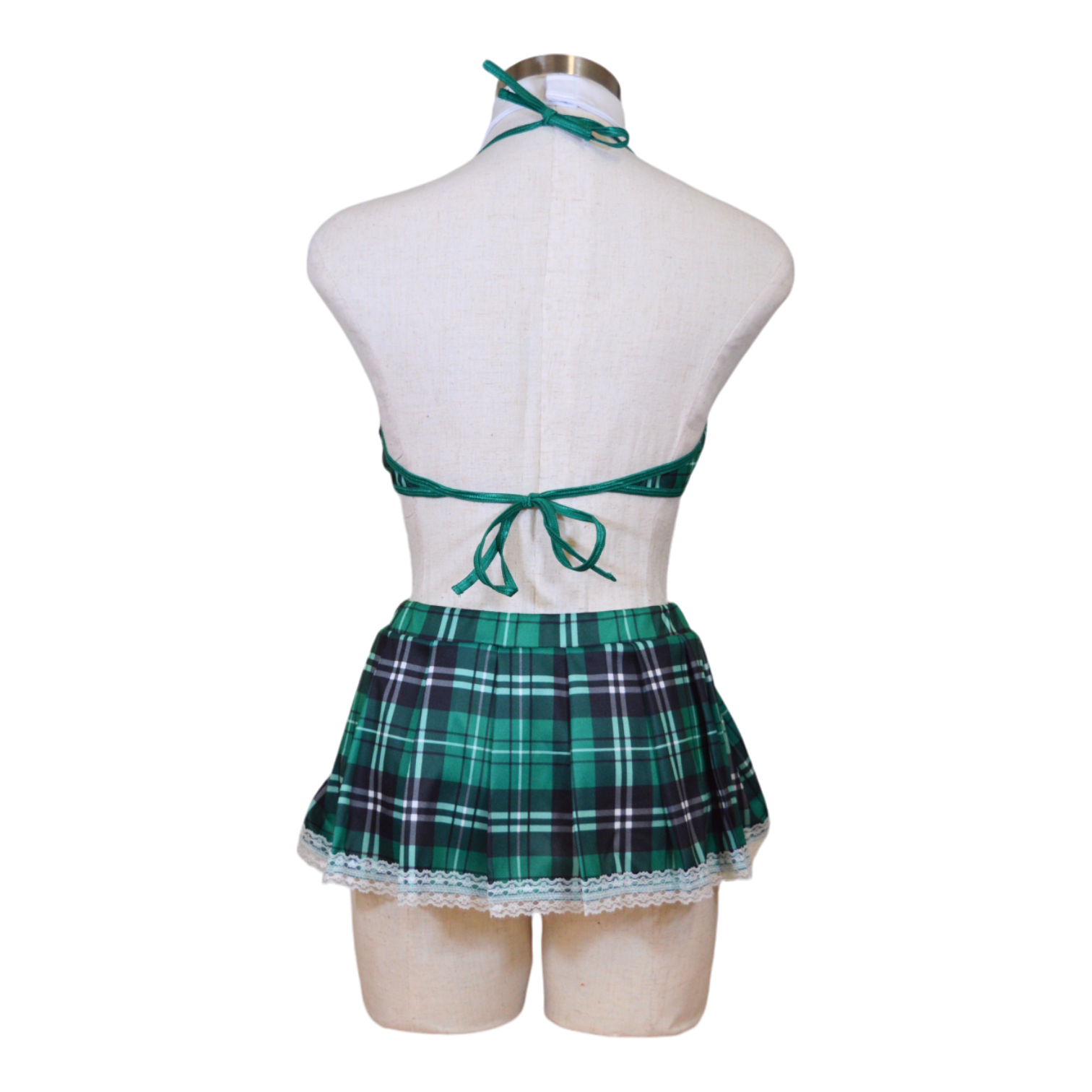 A mannequin wearing a green plaid schoolgirl costume with a bra top, skirt, and glasses.