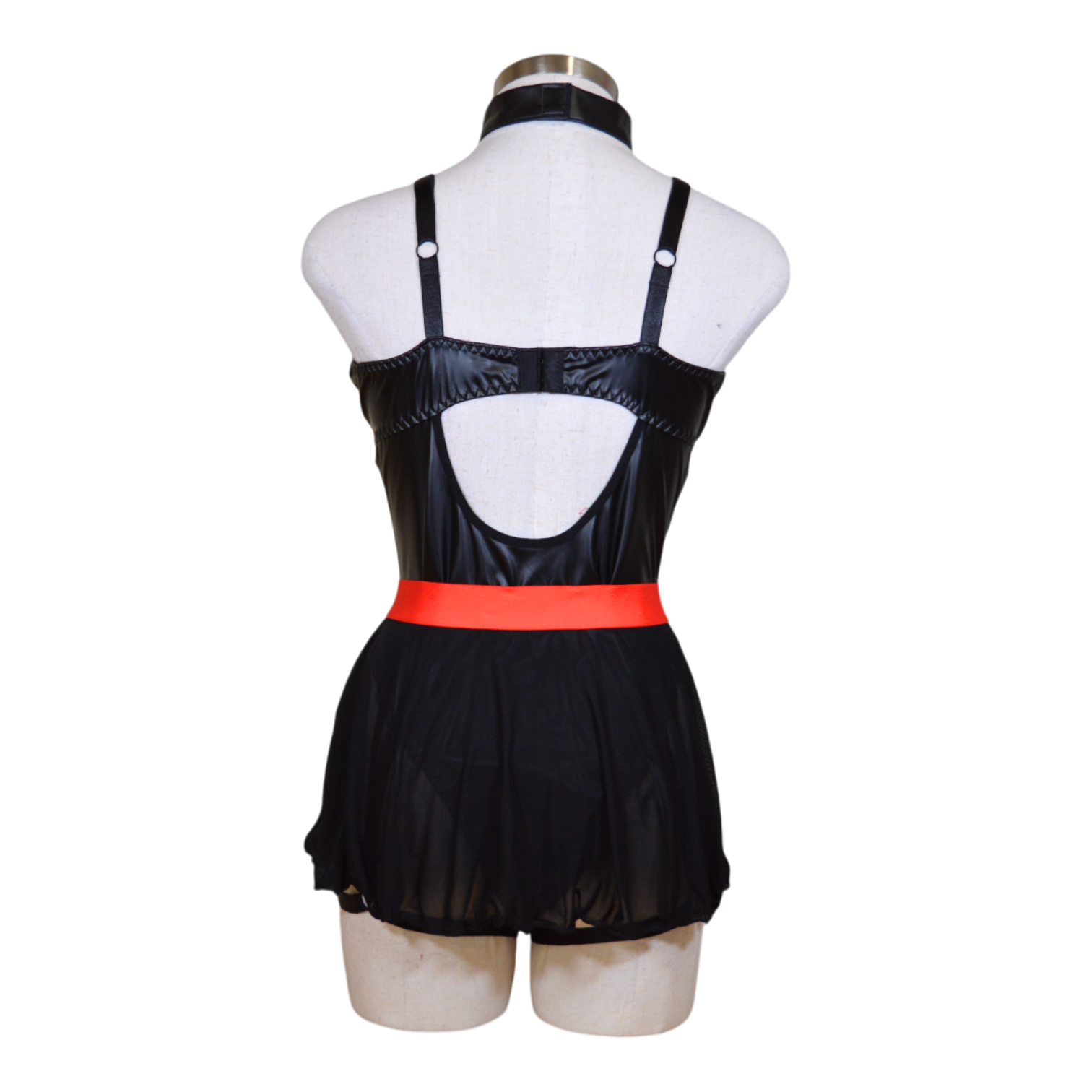 A black leather nurse costume displayed on a mannequin, featuring a revealing dress with red trim, a choker, and garter straps.