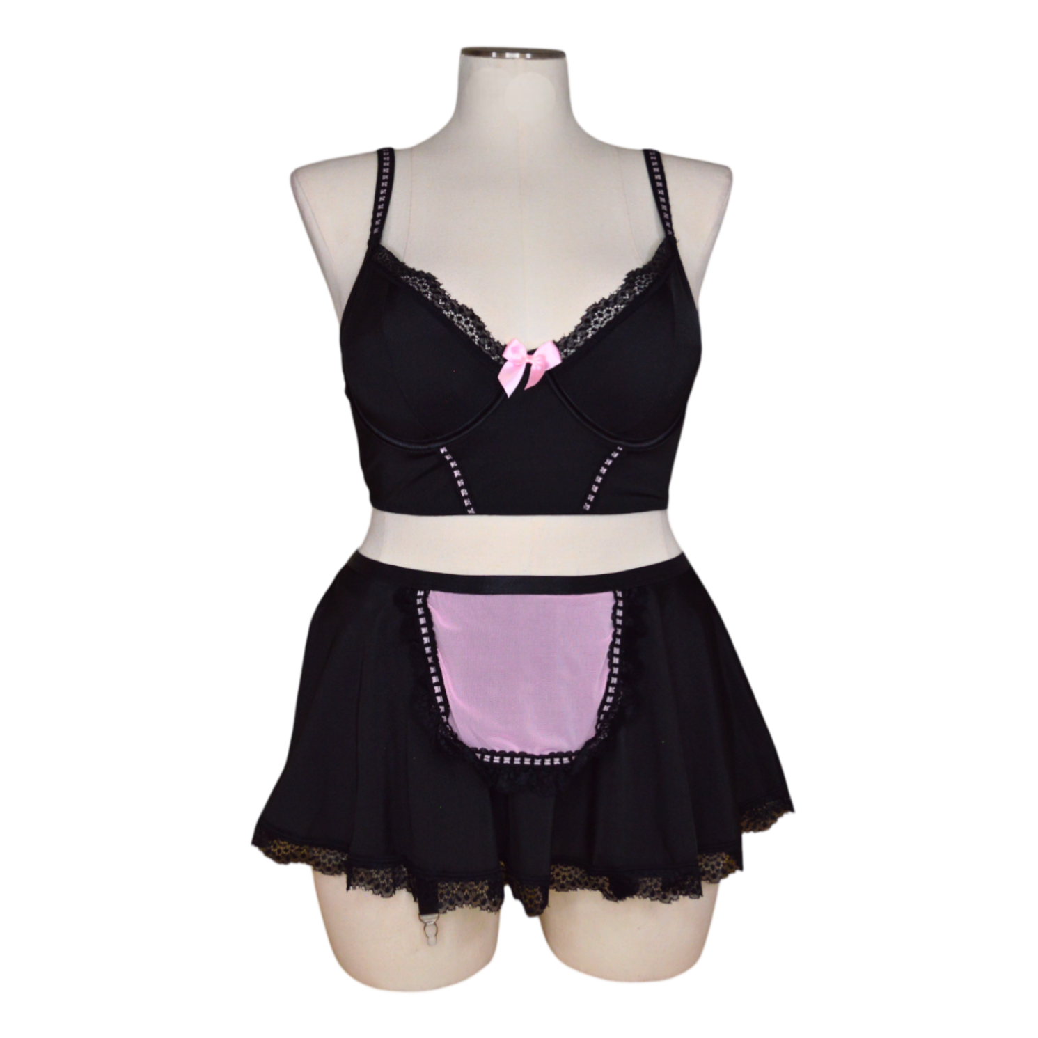 A black lingerie set with pink accents, featuring garter straps and lace detailing, displayed on a mannequin.