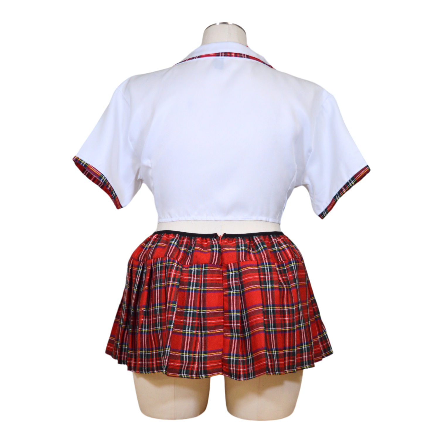 A mannequin displaying a white tie top and red and black plaid pleated skirt with necktie.