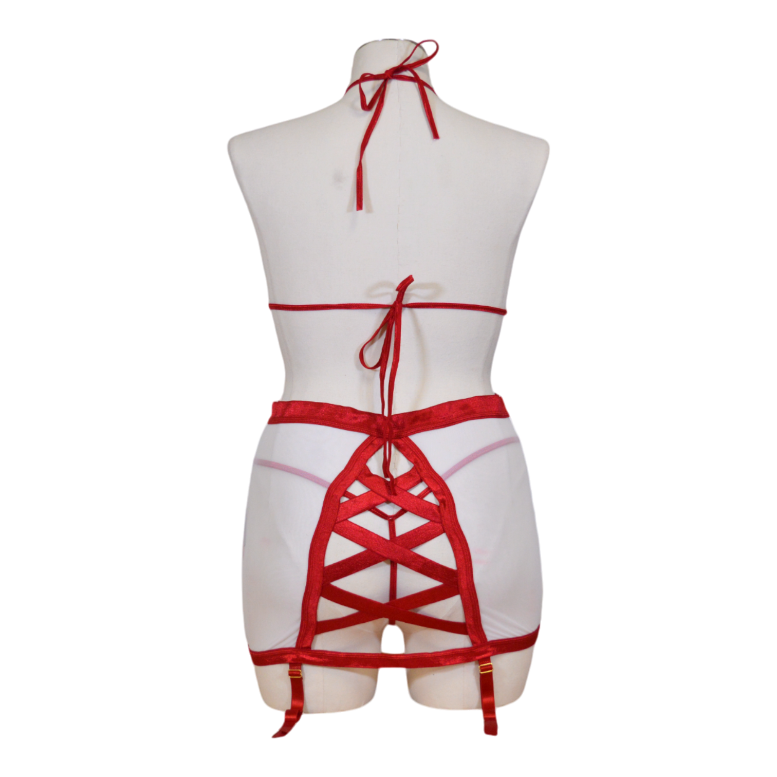 A red and white four piece nurse bra set on a mannequin, including a shiny satin elastic triangle bra, a high waist mesh skirt with strappy back detail and lace trim, a satin elastic thong, and a headpiece. Back view.