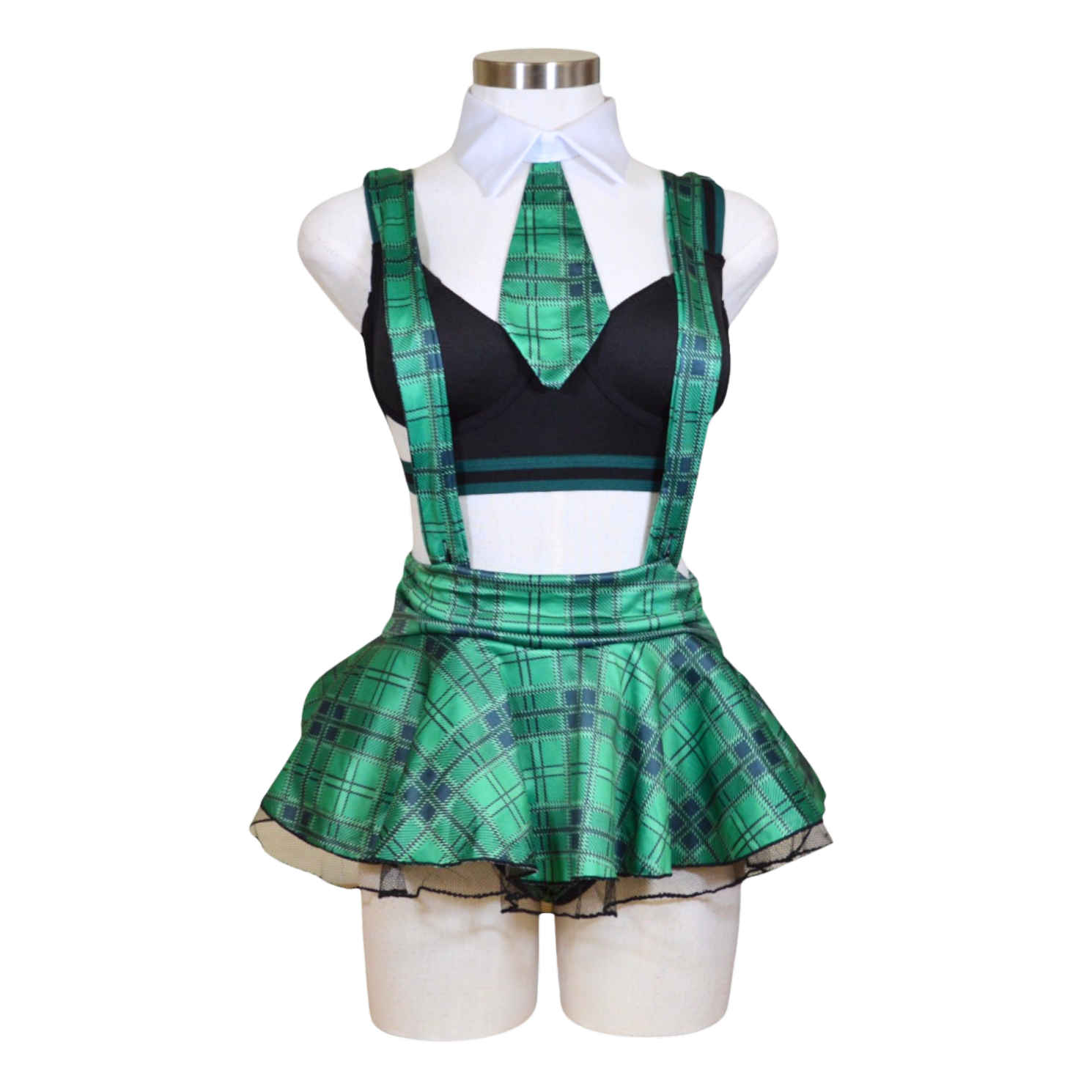 A mannequin displaying a black bra, green plaid skirt, necktie, and black panties arranged as a costume set