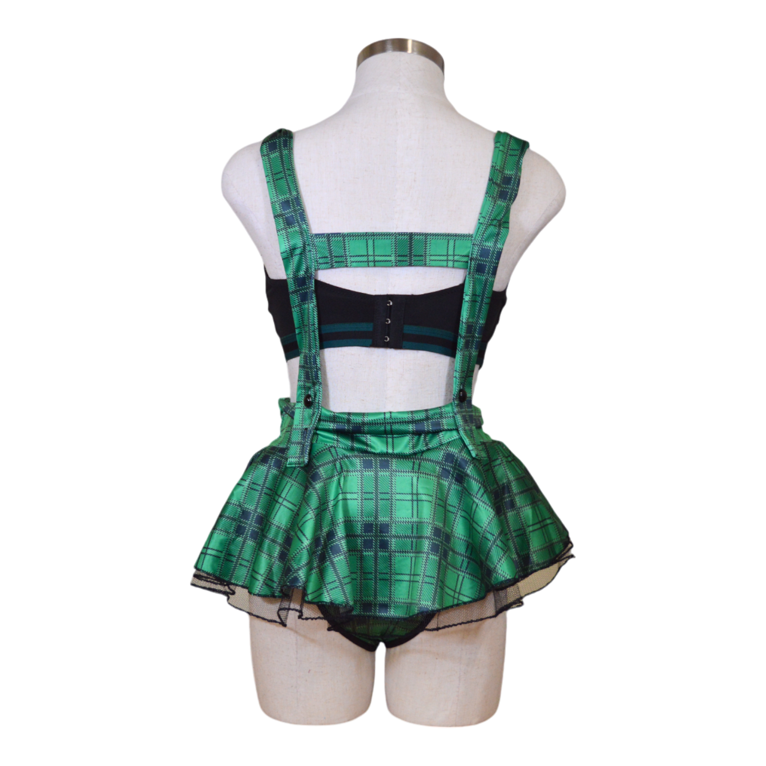A mannequin displaying a black bra, green plaid skirt, necktie, and black panties arranged as a costume set back view.