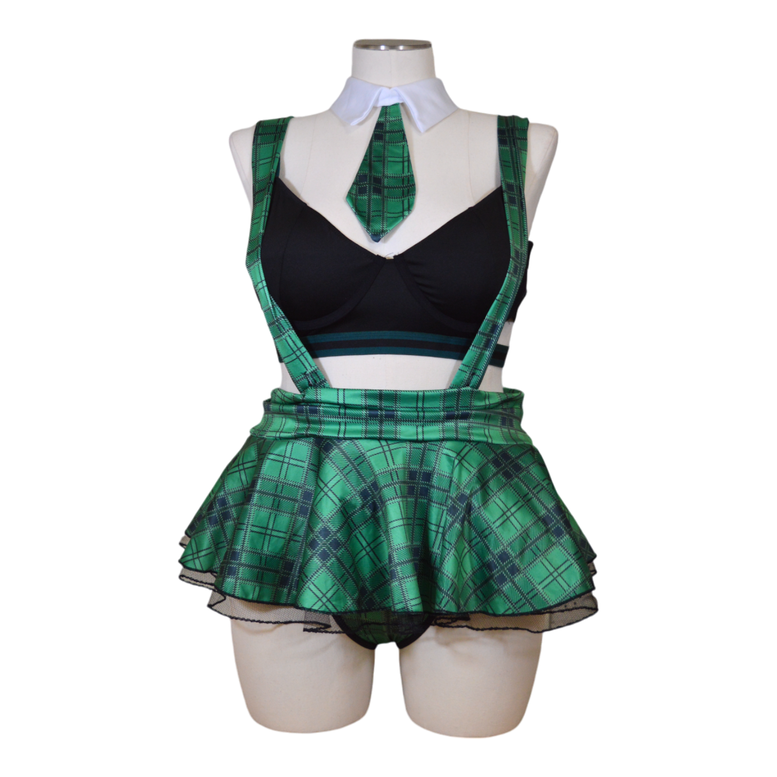 A mannequin displaying a black bra, green plaid skirt, necktie, and black panties arranged as a costume set.