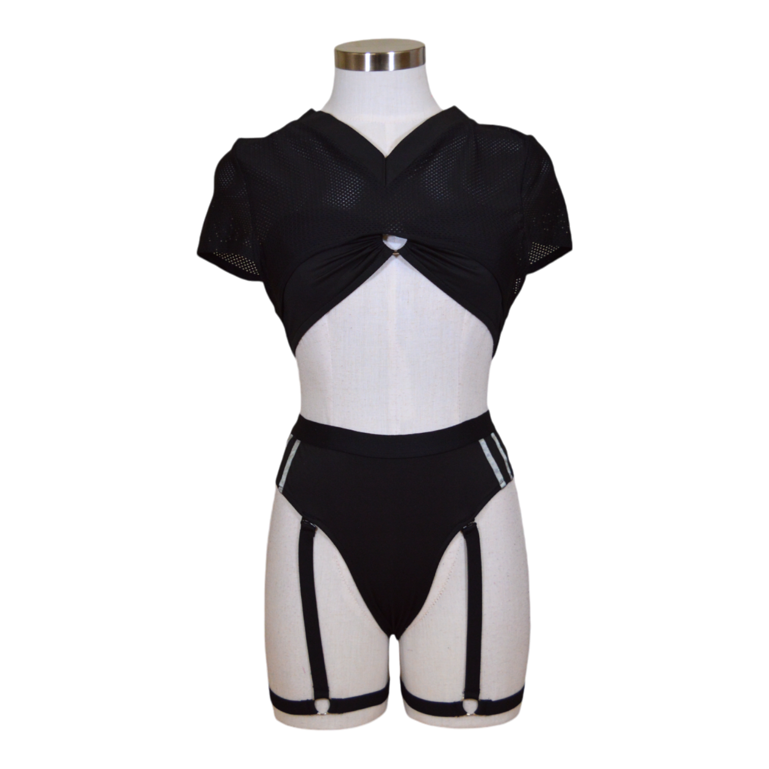 This image features a stylish and sporty three-piece set, designed for an athletic yet feminine appearance. The ensemble includes a form-fitting, black bra with a unique crisscross front, providing both support and a fashionable touch.