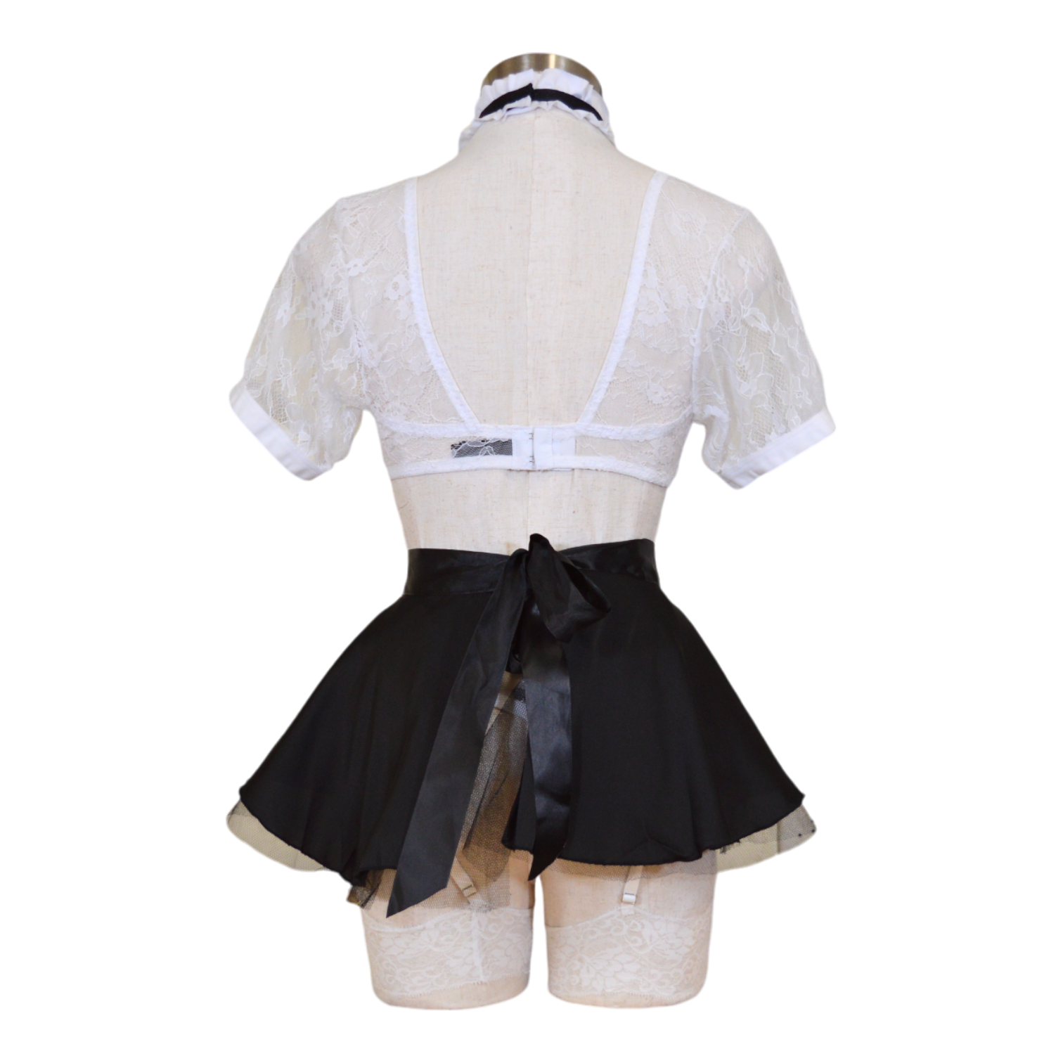 Mannequin wearing a white lace top and black skirt with a bow on a white background back view.