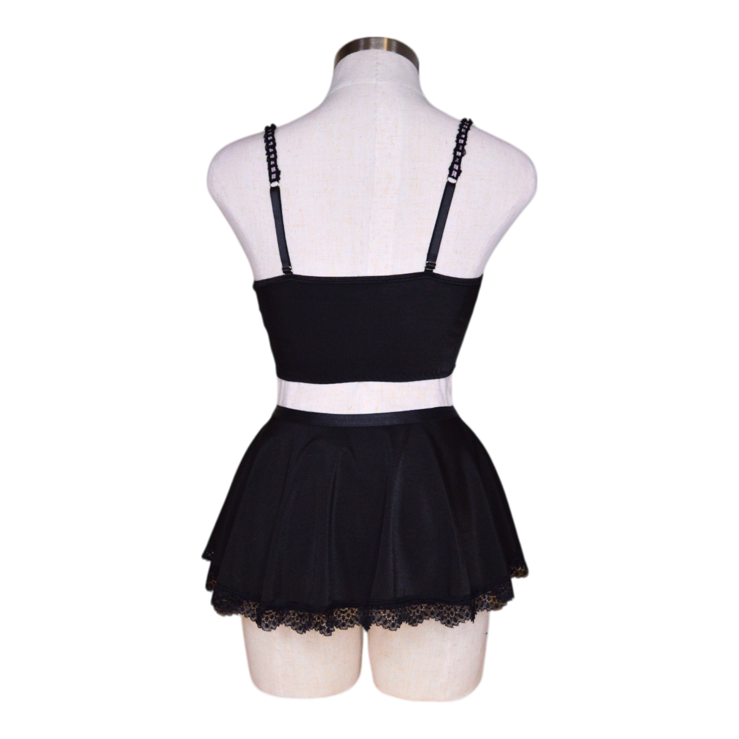 A black lingerie set with pink accents, featuring garter straps and lace detailing, displayed on a mannequin.