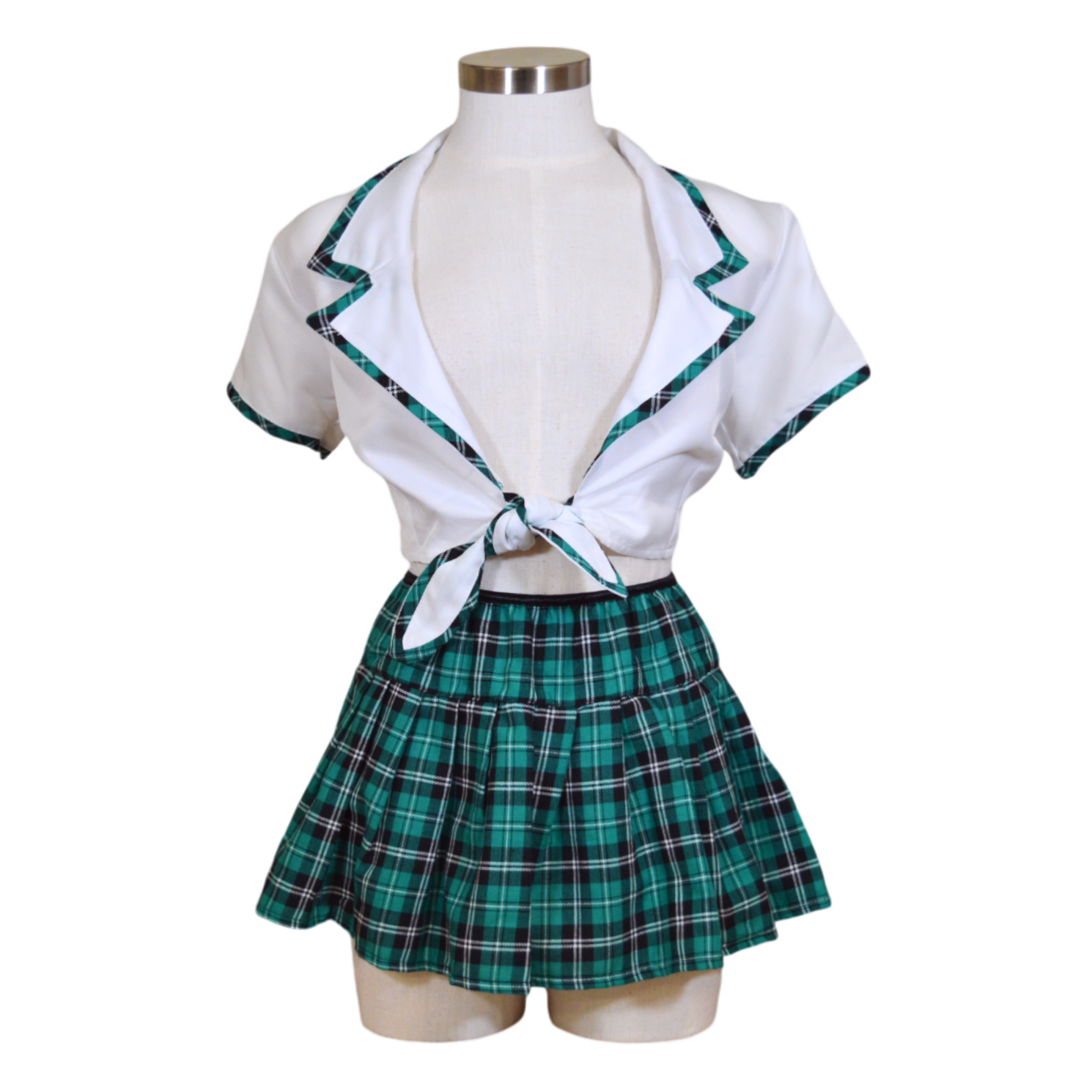 A mannequin wearing a white cropped top with a tie front and attached collar, and a matching plaid mini skirt with a plaid tie.