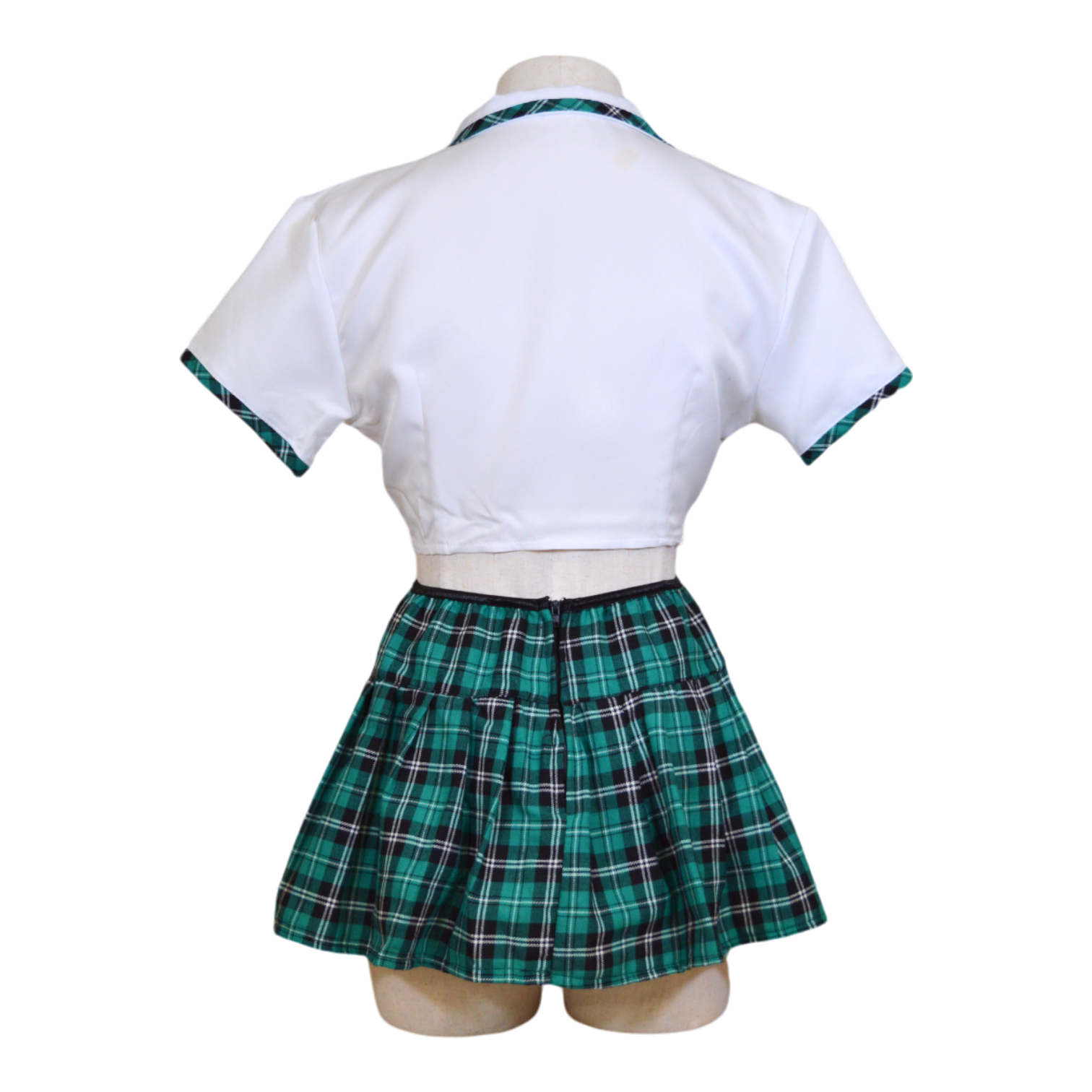 A mannequin wearing a white cropped top with a tie front and attached collar, and a matching plaid mini skirt with a plaid tie.